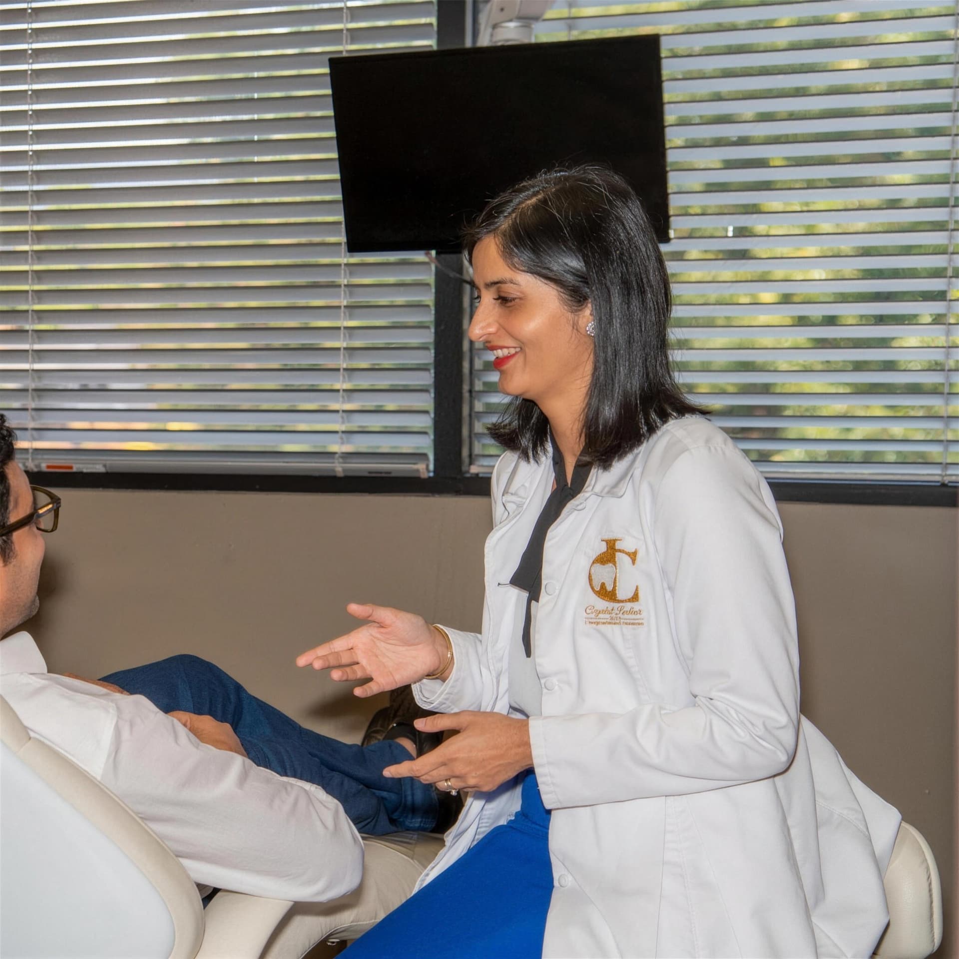 Dr. Crystal Ladhar talking with a patient seated in the treatment chair